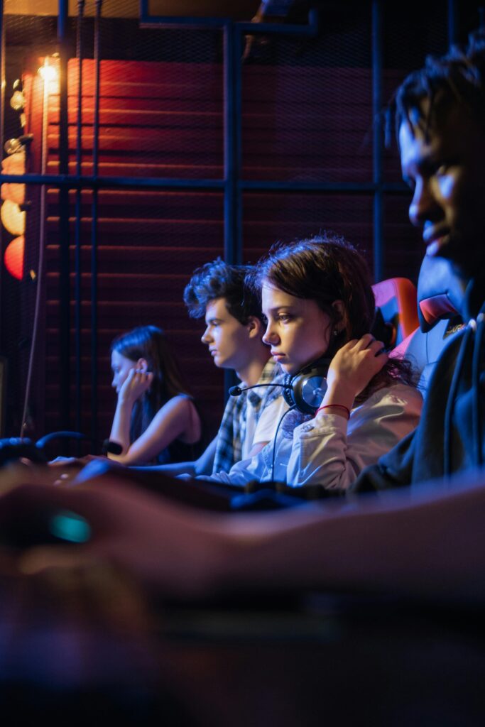 A group of young adults intensely focused on a gaming session, wearing headsets in an esports setting.