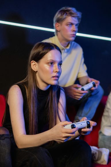 Young adults intensely focused on video gaming in a neon-lit room, exemplifying modern gaming culture.